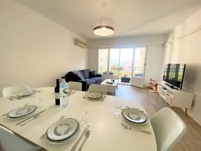 a living room with a white table and chairs at Appartement Sacré Coeur 6 couchages AJACCIO in Ajaccio