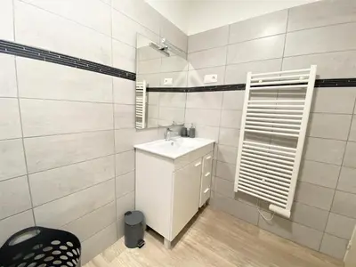 a white bathroom with a sink and a mirror at Appartement Sacré Coeur 6 couchages AJACCIO in Ajaccio