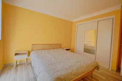 a yellow bedroom with a bed and a mirror at Appartement Eugénie centre-ville Ajaccio in Ajaccio