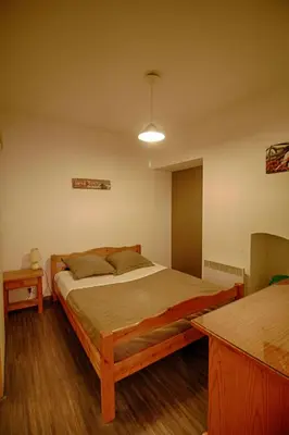 a bedroom with a wooden bed and a table at Studio Conventionnel Chiappe Vieille ville Ajaccio in Ajaccio