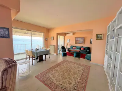a living room with a table and a couch at Appartement vue mer Carmino Ajaccio in Ajaccio