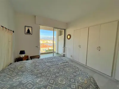 a bedroom with a large bed and a large window at Appartement vue mer Carmino Ajaccio in Ajaccio