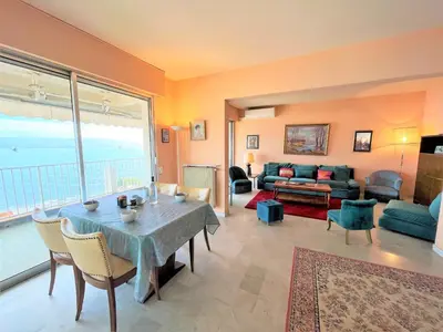 a living room with a table and a couch at Appartement vue mer Carmino Ajaccio in Ajaccio