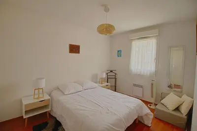 a bedroom with a white bed and a couch at Appartement Capo Rosso sanguinaires Ajaccio in Ajaccio