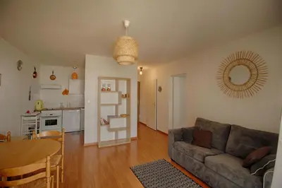 a living room with a couch and a table and a kitchen at Appartement Capo Rosso sanguinaires Ajaccio in Ajaccio