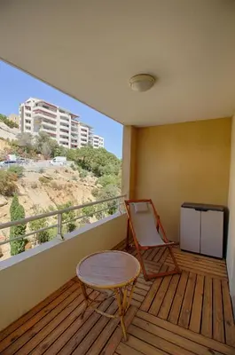 a room with a table and a chair on a balcony at Appartement Capo Rosso sanguinaires Ajaccio in Ajaccio