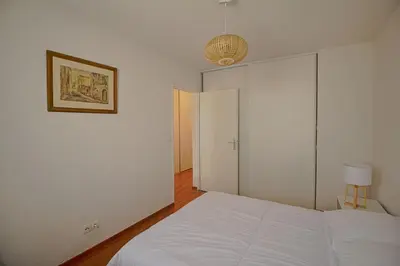 a bedroom with a white bed and a picture on the wall at Appartement Capo Rosso sanguinaires Ajaccio in Ajaccio