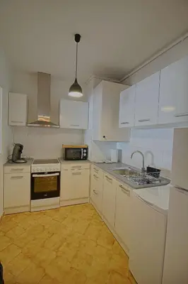 a white kitchen with white cabinets and a sink at Appartement Les Crêtes Sanguinaires Ajaccio in Ajaccio