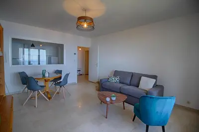 a living room with a couch and a table at Appartement Les Crêtes Sanguinaires Ajaccio in Ajaccio