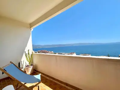 a balcony with a chair and a view of the ocean at Appartement le Sicile sanguinaires Ajaccio in Ajaccio