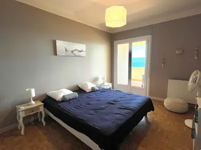 a bedroom with a bed and a window with the ocean at Appartement le Sicile sanguinaires Ajaccio in Ajaccio