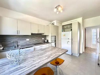 a kitchen with white cabinets and a counter top at Appartement le Sicile sanguinaires Ajaccio in Ajaccio