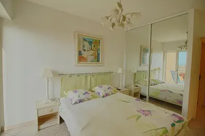 a bedroom with a bed and a large mirror at Appartement les Horizons sanguinaires Ajaccio in Ajaccio