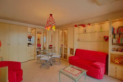 a living room with a red couch and a table at Appartement les Horizons sanguinaires Ajaccio in Ajaccio