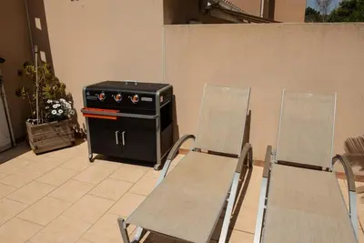 two chairs and a stove in a patio at Villa SYMPHONY A PIANA CORSE DU SUD in Piana