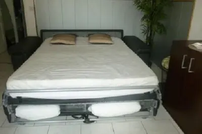 a bed with two pillows on it in a room at Villa SYMPHONY A PIANA CORSE DU SUD in Piana