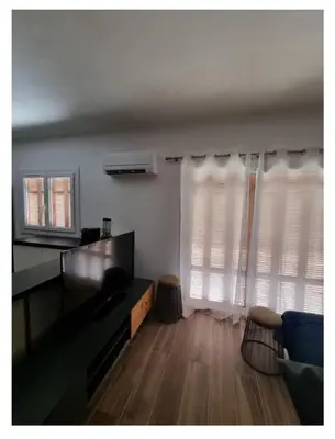a living room with a couch and two windows at Appartement proche plage in Ajaccio