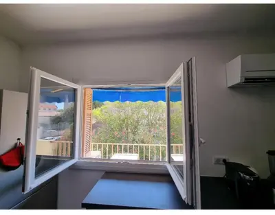 a room with a window with a view of a balcony at Appartement proche plage in Ajaccio