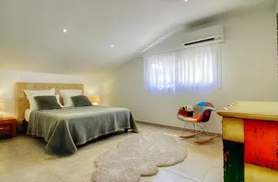 a bedroom with a bed and a window and a rug at Villa terranga in Calenzana