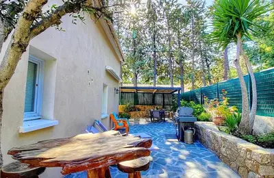 a patio with a table and chairs and a grill at Villa terranga in Calenzana