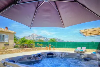 a large purple umbrella in a swimming pool at Villa terranga in Calenzana