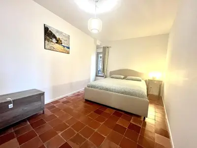 a bedroom with a bed and a tiled floor at Joli T3 sur le port de Bonifacio avec vue mer in Bonifacio