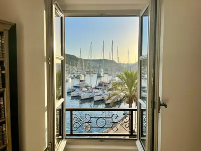 a room with a view of a marina with boats at Joli T3 sur le port de Bonifacio avec vue mer in Bonifacio