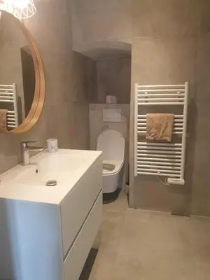 a bathroom with a sink and a toilet and a mirror at Joli T3 sur le port de Bonifacio avec vue mer in Bonifacio