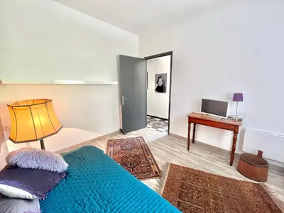 a bedroom with a bed and a table and a mirror at Appartement rez de villa CORTE in Corte