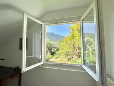 an empty room with a window with a mountain view at Appartement rez de villa CORTE in Corte