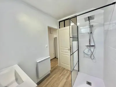 a bathroom with a shower and a glass door at Appartement rez de villa CORTE in Corte