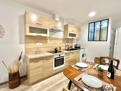 a kitchen with wooden cabinets and a wooden table at Appartement rez de villa CORTE in Corte
