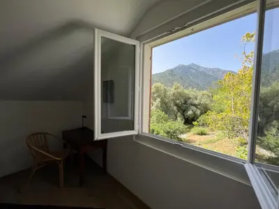 a room with a window with a chair and a desk at Appartement rez de villa CORTE in Corte