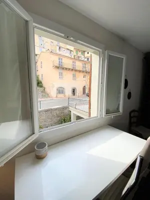 a window with a view of a building at Appartement Haut de Villa centre-ville CORTE in Corte