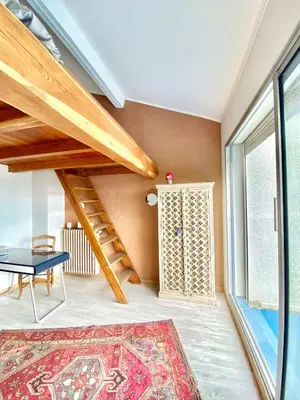 a living room with a staircase and a rug at Appartement Haut de Villa centre-ville CORTE in Corte