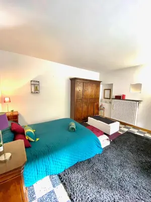 a bedroom with a large bed with a blue blanket at Appartement Haut de Villa centre-ville CORTE in Corte