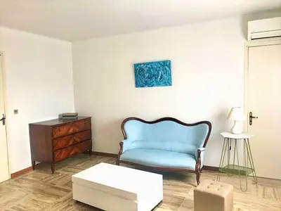 a living room with a blue chair and a table at Appartement Haut de Villa centre-ville CORTE in Corte