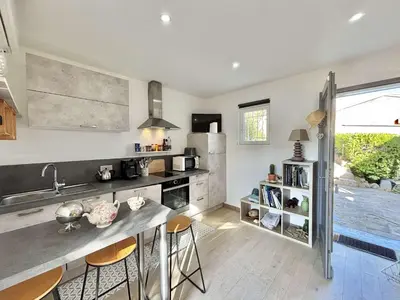 a kitchen with a counter and some chairs in it at Studio Le Prunelli PORTICCIO in Porticcio