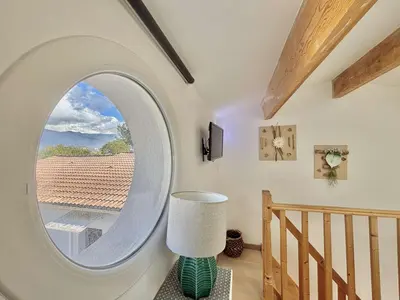 a round window in a room with a stairway at Studio Le Prunelli PORTICCIO in Porticcio
