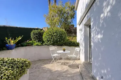 a patio with a table and chairs in a yard at Studio Le Prunelli PORTICCIO in Porticcio