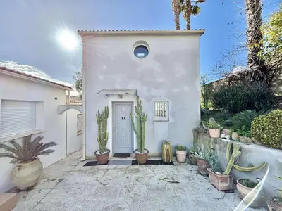 a white house with potted plants in front of it at Studio Le Prunelli PORTICCIO in Porticcio