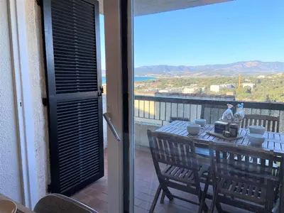 a balcony with a table with a view of the ocean at Appartement 86 Terra Bella 1 Porticcio in Porticcio