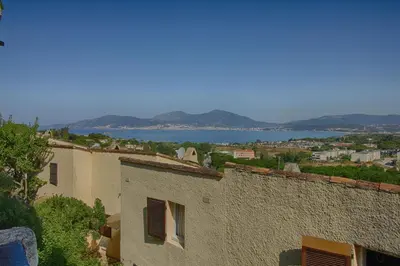a building with a view of the water behind it at Appartement 86 Terra Bella 1 Porticcio in Porticcio