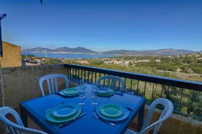 a blue table with chairs on a balcony with a view at Appartement 102 Terra Bella 1 Porticcio in Porticcio