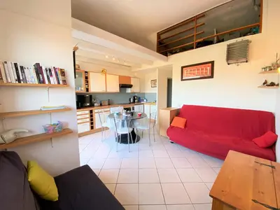 a living room with a red couch and a kitchen at Appartement 102 Terra Bella 1 Porticcio in Porticcio