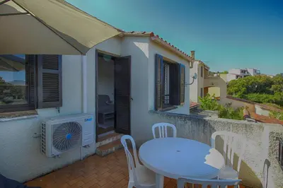 a table and chairs on the balcony of a house at Appartement 318 Paesolu 1 PORTICCIO in Porticcio