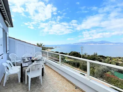 a balcony with a table and chairs and a view of the ocean at Appartement A Stagnola PORTICCIO in Porticcio