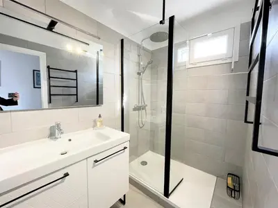a white bathroom with a shower and a sink at Appartement A Stagnola PORTICCIO in Porticcio