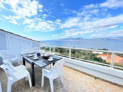 a table and chairs on a balcony with a view of the water at Appartement A Stagnola PORTICCIO in Porticcio