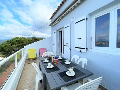 a patio with a table and chairs on a balcony at Appartement A Stagnola PORTICCIO in Porticcio